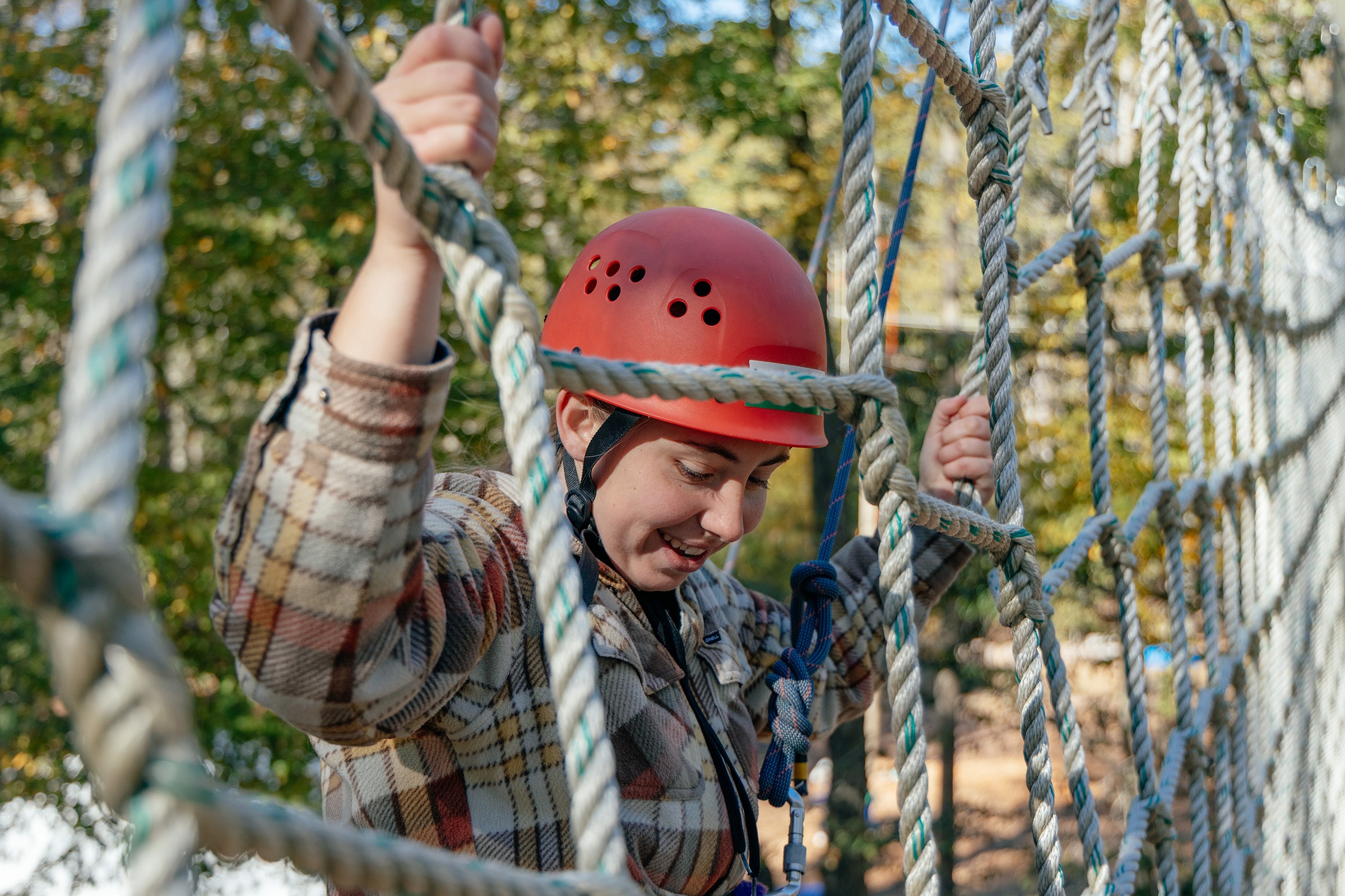 college student climbing a high ropes course